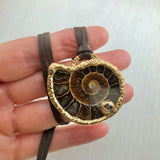 handmade fossiler ammonit schmuck anhänger aus madagaskar naturbelassen 22k vergoldet mit lederband fossiler schmuck stein anhänger ammonit naturstein schmuck von wonderworks 100 millionen jahre alt
